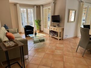 a living room with a couch and a tv at Villa Lavezzi avec piscine in Bonifacio