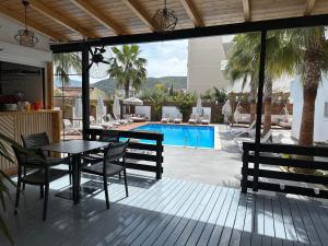 a patio with a table and chairs and a pool at Kuburi Hotel in Ksamil