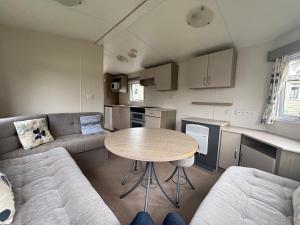 a living room with a couch and a table at Camping le quinquis in Clohars-Carnoët