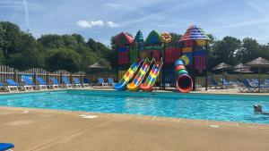 a swimming pool with a water park with a playground at Camping le quinquis in Clohars-Carnoët