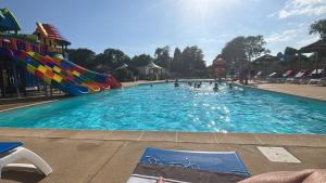 a large swimming pool with a water slide at Camping le quinquis in Clohars-Carnoët +9 photos