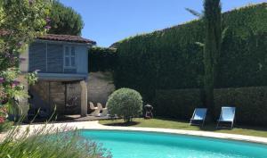 a swimming pool in a garden with two chairs and a house at Large house - Garden pool in Cognac
