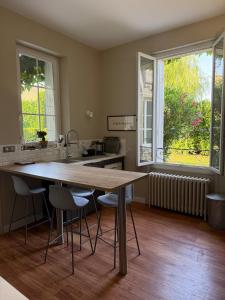 a kitchen with a wooden table and two windows at Large house - Garden pool in Cognac