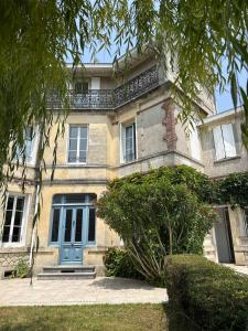a large brick house with a blue door at Large house - Garden pool in Cognac