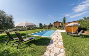two chairs and an umbrella next to a swimming pool at Agriturismo Dolce Colle in Volpago del Montello
