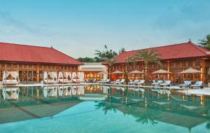 a resort with a swimming pool with chairs and umbrellas at Paradisus by Meliá Bali in Nusa Dua