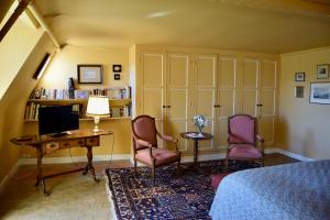 a bedroom with a desk and two chairs and a computer at Chateau de Vaux in Yvré-lʼÉvêque