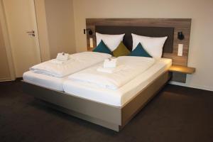 a bedroom with a large bed with blue and white pillows at Hotel & Tagungszentrum Blaubeuren - Hessenhöfe in Blaubeuren +40 photos
