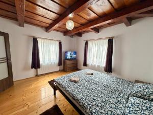a bedroom with a bed in a room with wooden ceilings at Medelore Cottage in Medişoru Mare