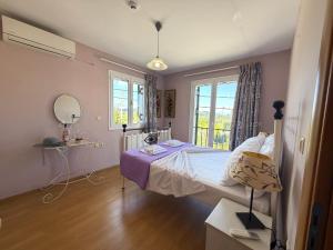 a bedroom with a bed and a mirror and a window at Sunlit Village Escape in Kompítsion +40 photos