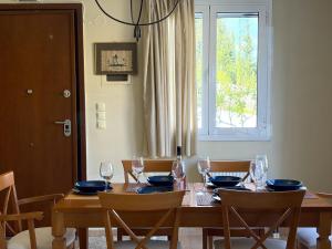 a dining room table with glasses and blue plates on it at Sunlit Village Escape in Kompítsion