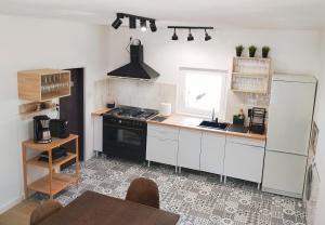 a kitchen with white cabinets and a black stove at Finca Segade in A Estrada