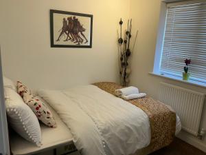 a bed in a bedroom with a picture on the wall at Home away from away in Dartford