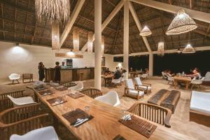 a restaurant with a large wooden table and chairs at Mazava Loha Resort in Antsiranana