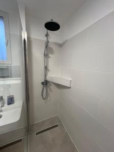 a white bathroom with a shower and a sink at Avella House in Mühlheim +23 photos