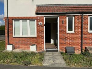 a brick house with a door and a window at Home away from away in Dartford