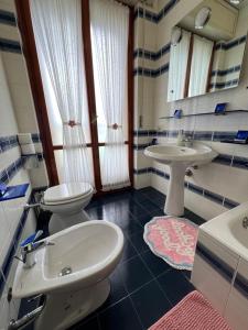 a bathroom with two sinks and a toilet and a mirror at The little lake Verona villa in Bovo +77 photos