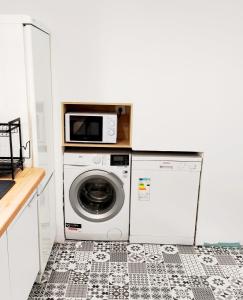 a kitchen with a washing machine and a microwave at Finca Segade in A Estrada