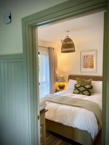 a bedroom with a bed and a chandelier at Rhubarb Cottage in Navan