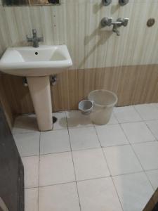 a bathroom with a sink and a bucket at Hotel Grand Inn in Haridwār