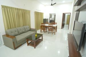 a living room with a couch and a table at Radial Serviced Apartments in Chennai