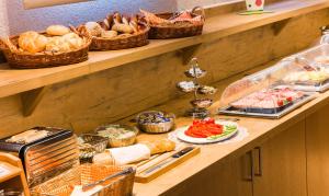 a shelf with bread and baskets of food on it at Ambient Hotel am Europakanal in Fürth +105 photos