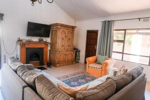 a living room with a couch and a fireplace at Whitehouse- Hot Tub in Elands Bay