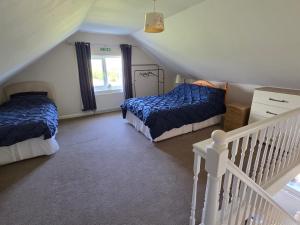a attic bedroom with two beds and a staircase at Coastal Annex at Saltfleet in Saltfleet