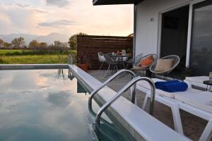 a house with a swimming pool with a table and chairs at Olympus Pool Retreat in Katerini