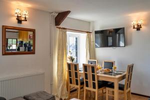 a dining room with a table and chairs and a window at Finest Retreats - Trimstone Manor, Manor Cottage in Woolacombe