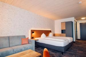a hotel room with a bed and a couch at iQ-Hotel Ulm in Ulm