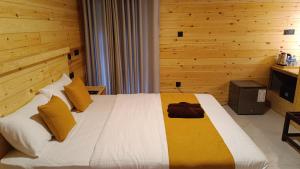 a bedroom with a large bed with wooden walls at Wood Gold Ella in Ella