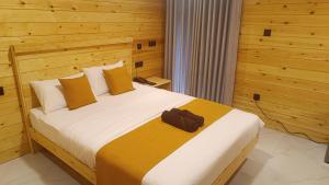 a bedroom with a large bed with a brown bag on it at Wood Gold Ella in Ella