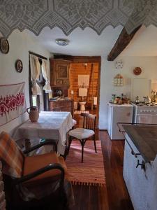 a kitchen with a table and a kitchen with a stove at Fecskefészek Vendégház Őriszentpéter in Őriszentpéter