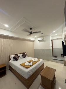 a bedroom with a bed with a table and a ceiling at Hotel Kalp Rooms in Vyāra