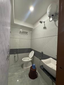 a bathroom with a toilet and a sink at Hotel Kalp Rooms in Vyāra +31 photos