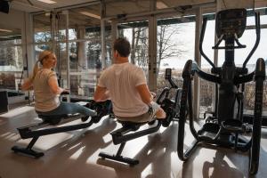 a man and woman riding on exercise bikes in a gym at Ruissalo Spa Hotel in Turku +63 photos