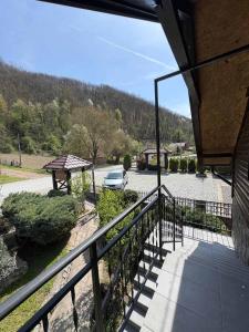 a balcony with a car parked on a street at Konaci kod Bobe in (( Vratna ))