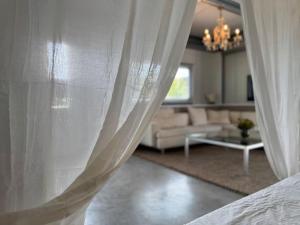 a living room with white curtains and a couch at Private Apartment Retreat in Breda