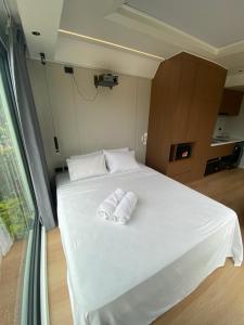 a bedroom with a white bed with two towels on it at Lionheart Roslyn Suite 2 in Nuku‘alofa