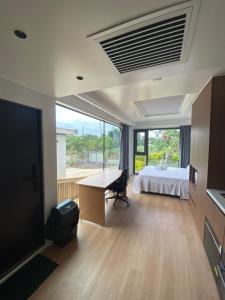 a room with a bed and a desk and a television at Lionheart Roslyn Suite 2 in Nuku‘alofa