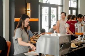 a woman is preparing food in a restaurant at H- Dragon Hotel in Ðố Sơn +37 photos