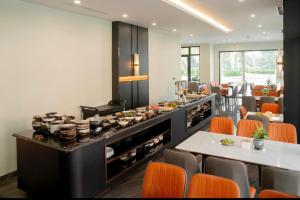 a restaurant with orange chairs and a buffet at H- Dragon Hotel in Ðố Sơn