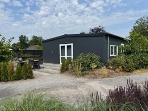 a black tiny house with a patio at Private Apartment Retreat in Breda
