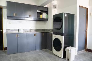 a kitchen with a washer and dryer in a room at Wanderers Backpacker Condotel in Pusok +77 photos