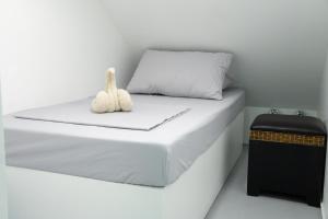 a white bed with a stuffed animal sitting on it at Wanderers Backpacker Condotel in Pusok