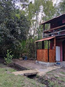 a house with a porch and a refrigerator in front of it at Bangalo O Galo in Itacaré