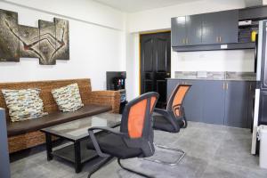 a living room with a couch and chairs and a table at Wanderers Backpacker Condotel in Pusok
