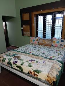 a large bed in a bedroom with a flowery quilt at meadowell homestay in Kizhake Chālakudi +5 photos