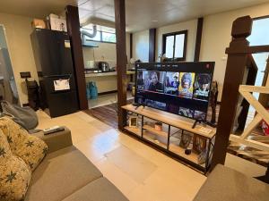 a living room with a flat screen tv on a table at Pads Guesthouse in San Vicente